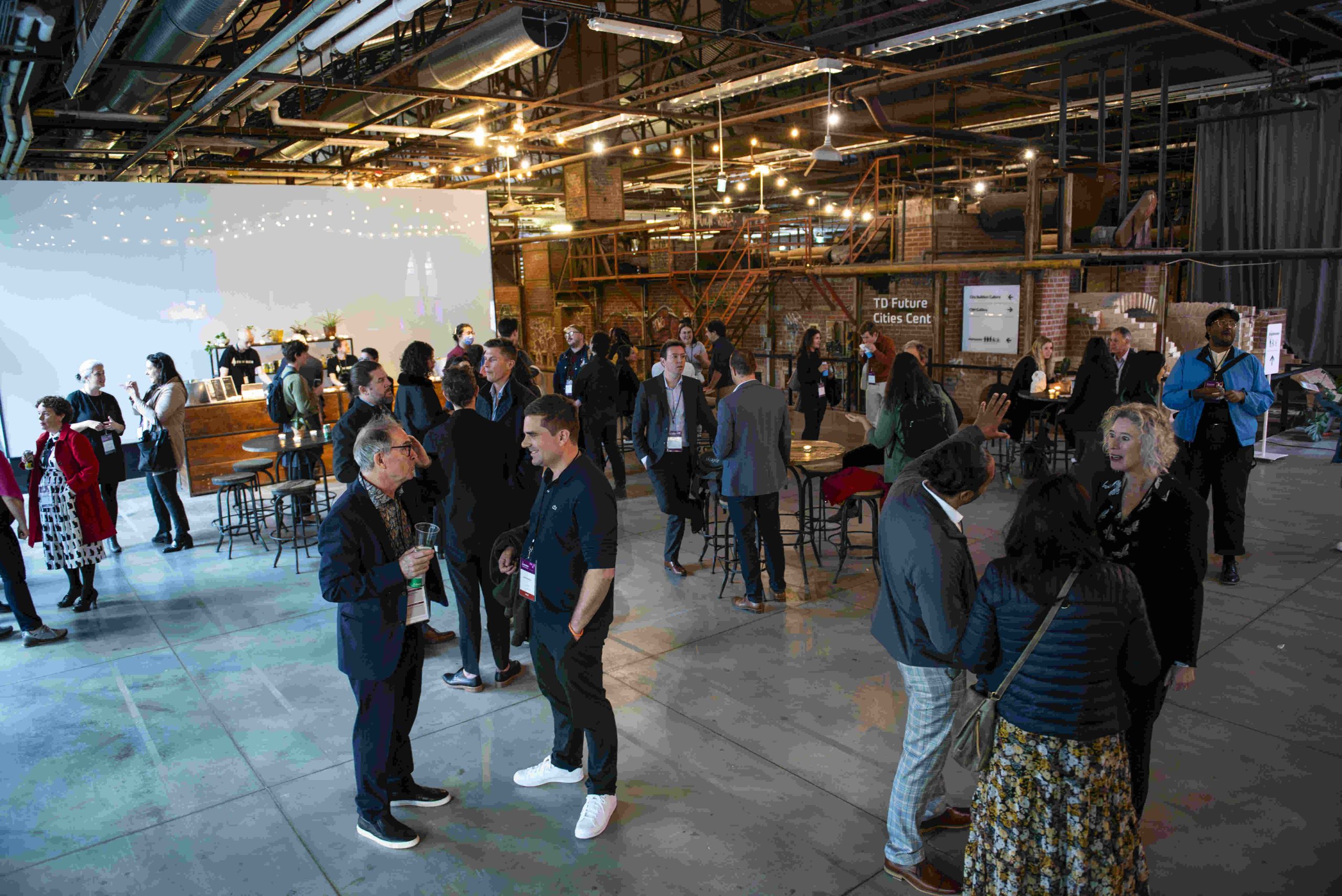 People mingle around during networking event in industrial looking indoor space