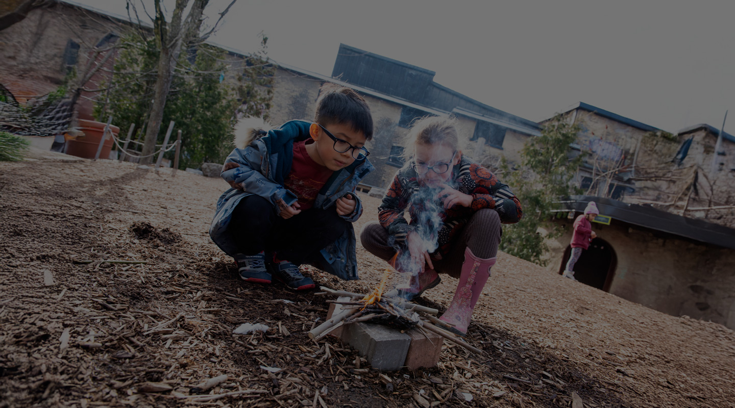 Two kids building a fire