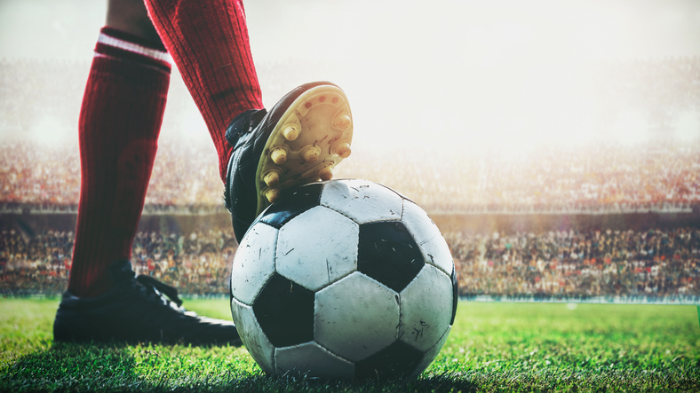feet-of-soccer-player-tread-on-soccer-ball-for-kick-off-in-the-stadium