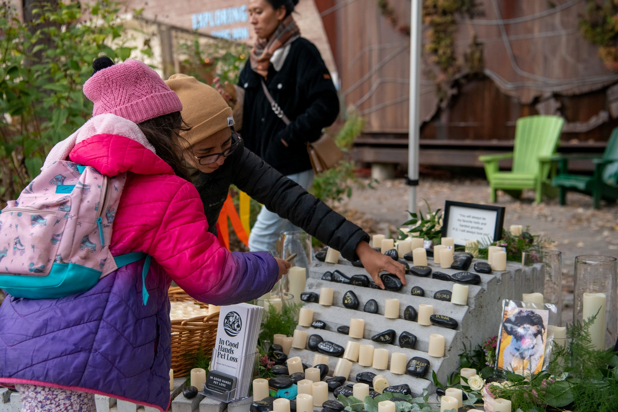 Two people place stones on altar in remembrance of a pet they lost.