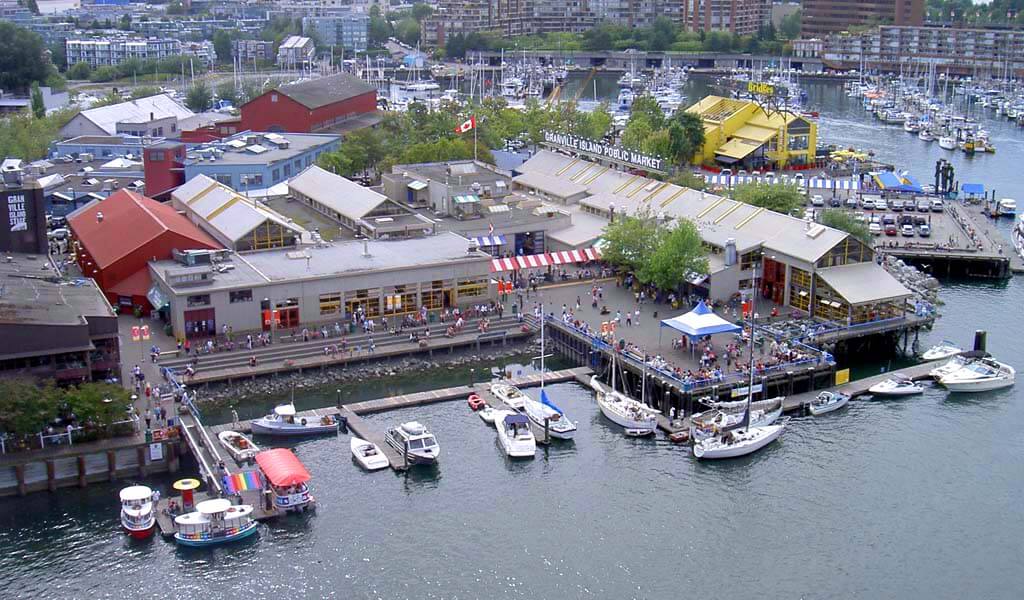 Arial photo of Granville island showing water, boats, buildings and pedestrian walks