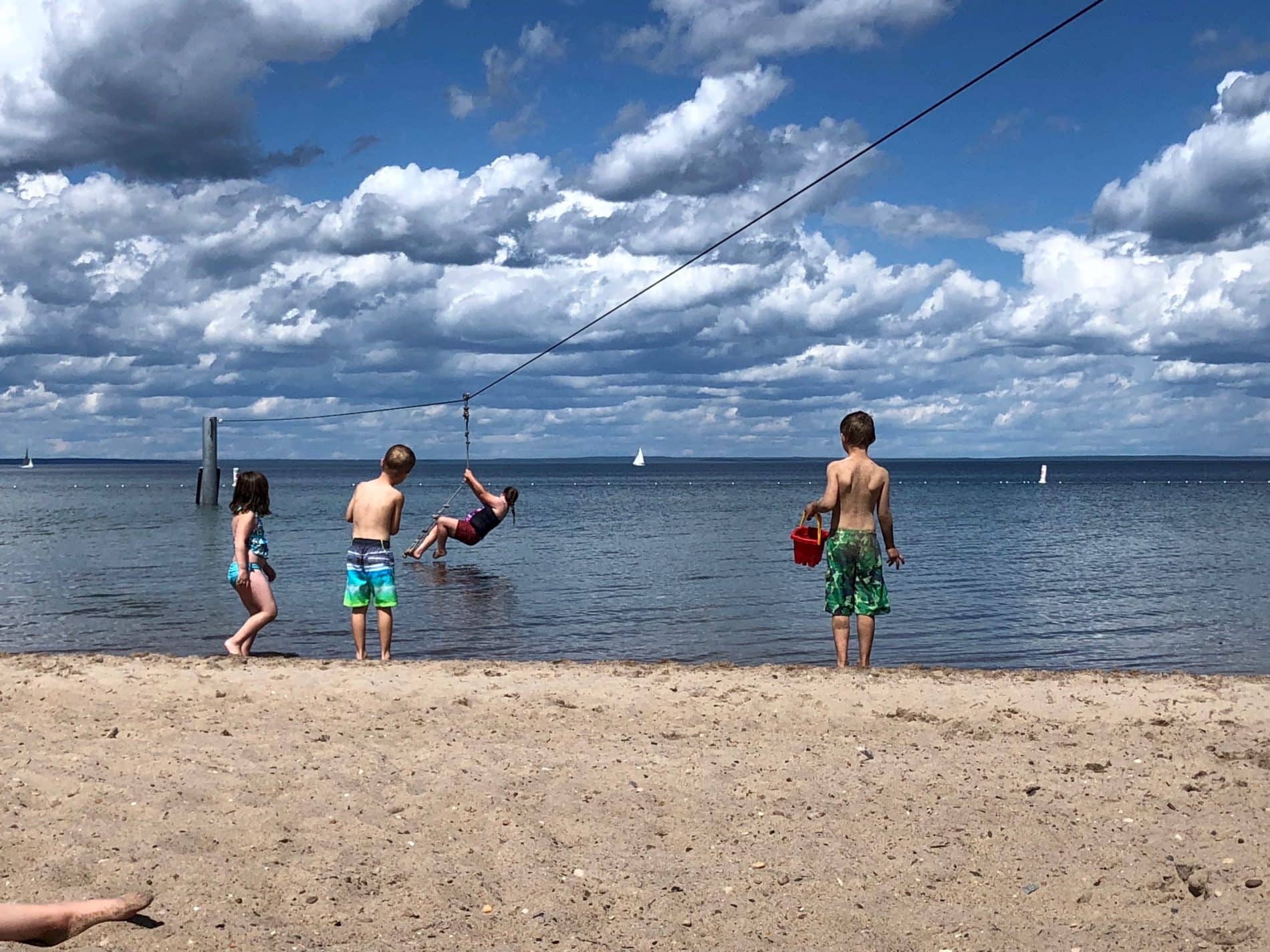 Group of children at beach zipline into water