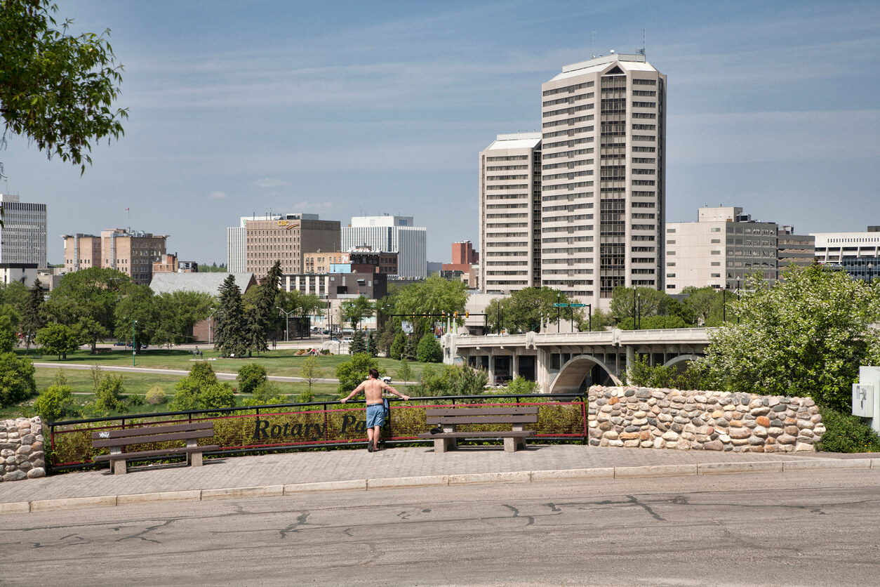 Person in green space overlooking downtown Saskatoon